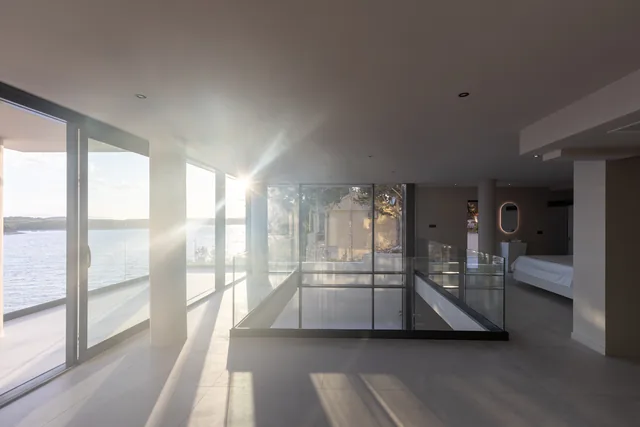 Sunlight over the glass atrium and sea-facing bedroom level